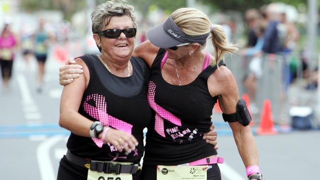 Kerry Lunn and Carolynn Rothewell cross the finish line after completing an 8km run at the Gold Coast Mother's Day Classic in support of breast cancer research.