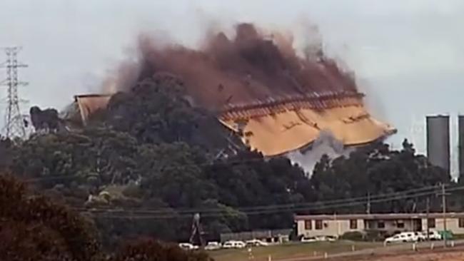 Smoke rises as the building falls.