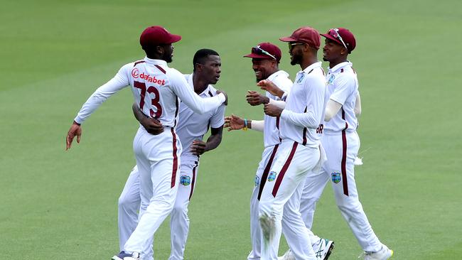 Shamar Joseph celebrates with team mates after guiding his side to a win at the Gabba against Australia. Picture: Bradley Kanaris/Getty Images.