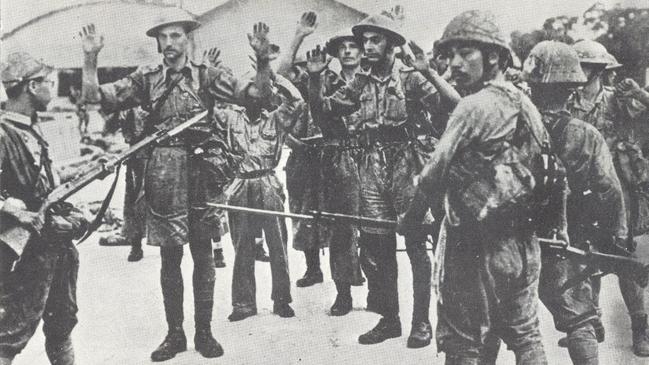 Japanese troops with fixed bayonets guard Allied prisoners after the fall of Singapore.