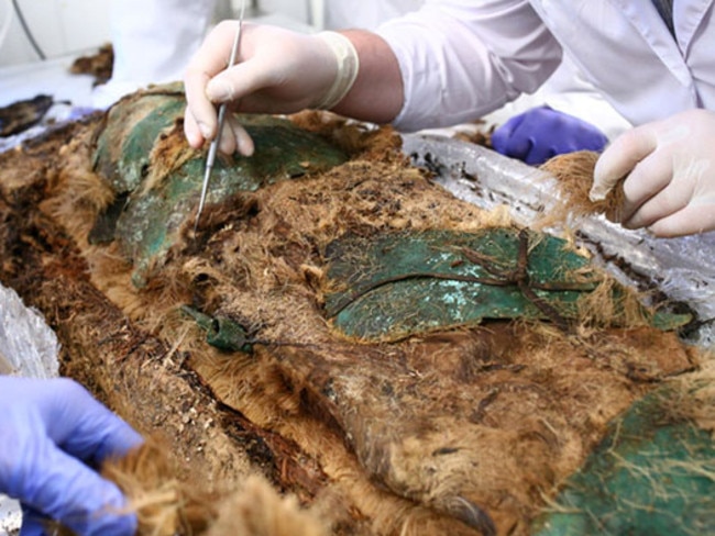 The mummified child is carefully removed from its wraps. Source: Siberian Times