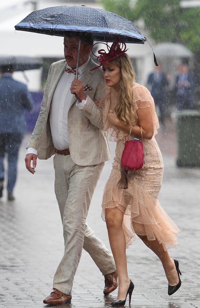 Racegoers run for cover. Picture: AAP Image/Dan Himbrechts