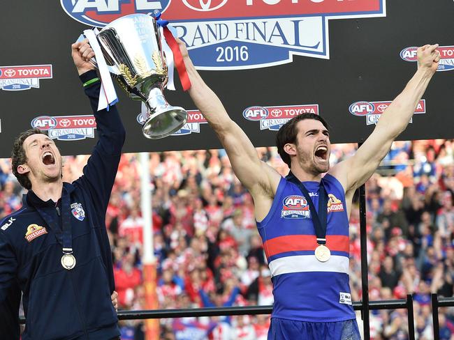 Bulldogs coach Luke Beverridge (left) injured captain Robert Murphy and acting captain Easton Wood hold the trophy after winning the AFL Grand Final between the Sydney Swans and the Western Bulldogs at the MCG in Melbourne, Saturday, Oct. 1, 2016. (AAP Image/Julian Smith) NO ARCHIVING, EDITORIAL USE ONLY