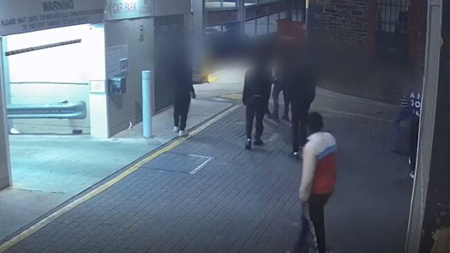 CCTV footage shows Machok, in the red and white jacket, approaching the victim. Photo: Courts SA