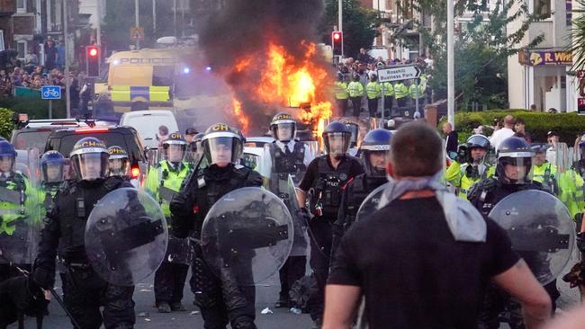 Riot police hold back protesters near a burning police vehicle after disorder broke out on July 30, 2024 in Southport, England. Picture: Getty Images/Getty Images