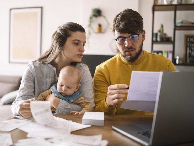 Young family with baby worried about family budget and high taxes and bills. Inflation concept.