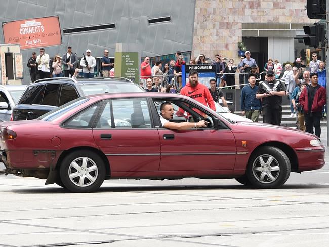 A man was captured by Herald Sun photographer Tony Gough driving erratically on the corner of Swanston and Flinders St. Picture: Tony Gough