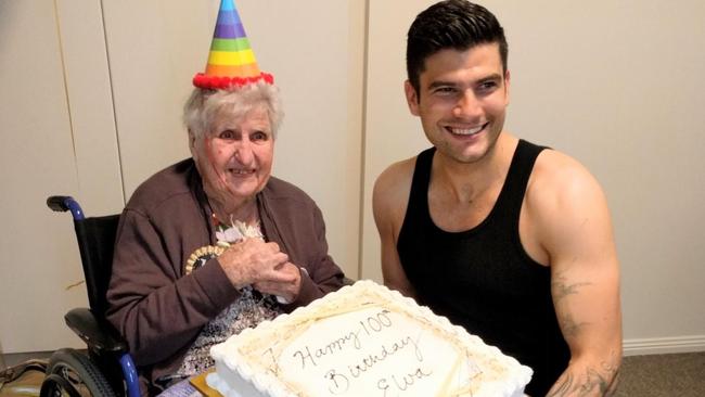 Elva Larsen on her 100th birthday with stripper Johnny Star and her birthday cake.