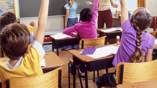 f33openday - View of children with their hands raised in class. thinkstock