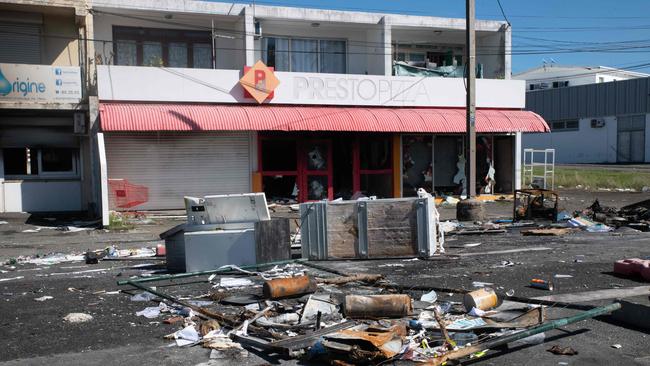 Charred debris is seen in front of a damaged restaurant in the Magenta district of Noumea, New Caledonia. Picture: Delphine Mayeur / AFP