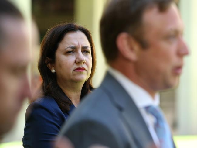 Premier Annastacia Palaszczuk watches on as Health Minister Steven Miles addresses the media yesterday. Picture: Jono Searle/Getty Images