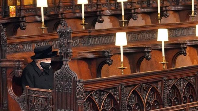 The Queen sits alone in St George's Chapel.