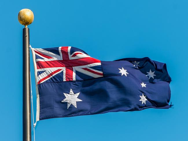 The Australian flag against clear blue sky