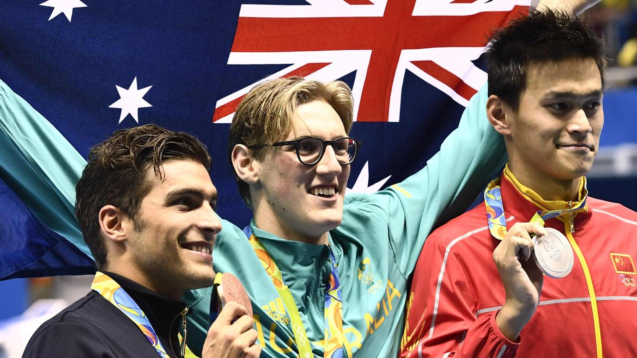 Australia's Mack Horton holds the Australian flag as he poses on the podium with silver medallist China's Sun Yang and bronze medallist Gabriele Detti in Rio.
