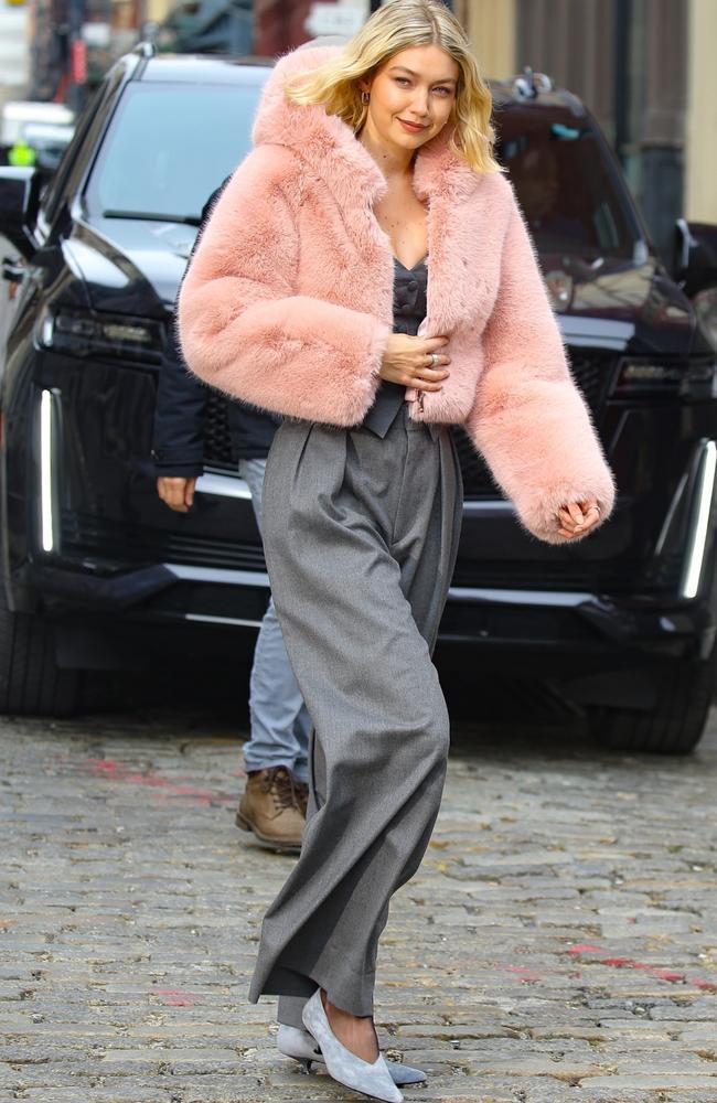 For her second, softer look, she wore charcoal grey, high-waisted pants with a matching bustier top, adding a pop of colour via a pink fuzzy, fur jacket.. Picture: BACKGRID Australia