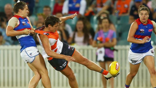 Courtney Gum manages to get a kick away despite a tackle from Emma Kearney. Picture: Getty