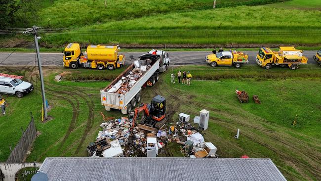 Local residents and Rural Fire Brigade members join Cassowary Coast Council workers clean up a flooded properties on Gregory Street, Cardwell. Picture: Brendan Radke