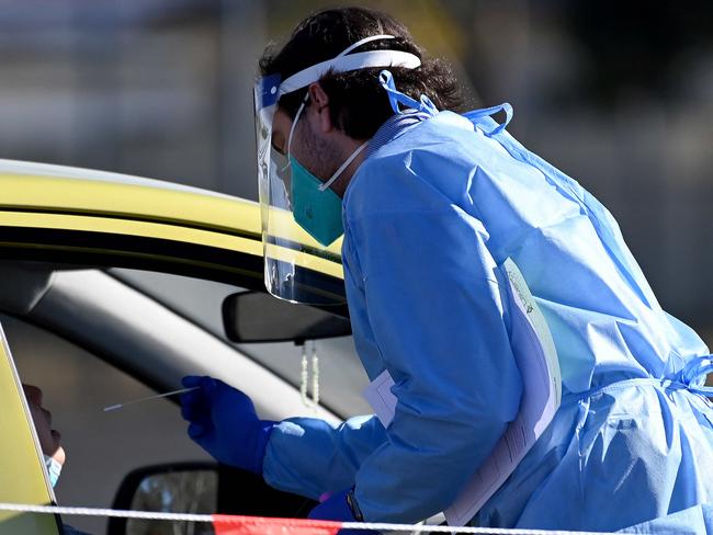 SYDNEY, AUSTRALIA - NewsWire Photos - JULY, 13, 2021: Health workers dressed in Personal Protection Equipment (PPE) conduct COVID-19 tests at the new 24/7 Fairfield West Laverty Pathology Pop-up Drive-through clinic, in Sydney. New South Wales has recorded 89 new locally transmitted coronavirus cases overnight, 21 of which were infectious during their time in the community, with new testing orders for essential workers in Fairfield and Greater Sydney kicking in at 12.01am tomorrow. Picture: NCA NewsWire/Bianca De Marchi