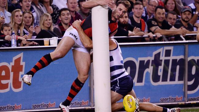 Jobe Watson is tackled into the point post by James Podsiadly in 2013.