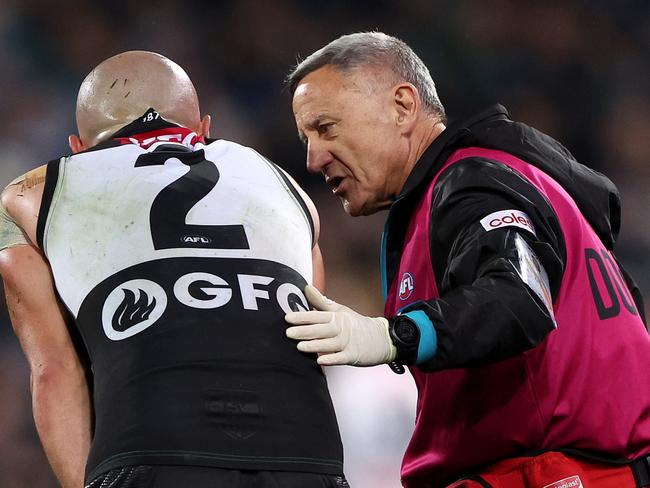 ADELAIDE, AUSTRALIA - JULY 22: Sam Powell-Pepper of the Power in the hands of the club doctor during the 2023 AFL Round 19 match between the Port Adelaide Power and the Collingwood Magpies at Adelaide Oval on July 22, 2023 in Adelaide, Australia. (Photo by Sarah Reed/AFL Photos via Getty Images)