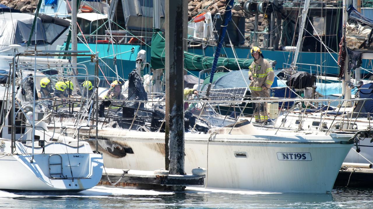 The fire extinguished, fire fighters survey the burnt out hull. Picture: Dean Martin