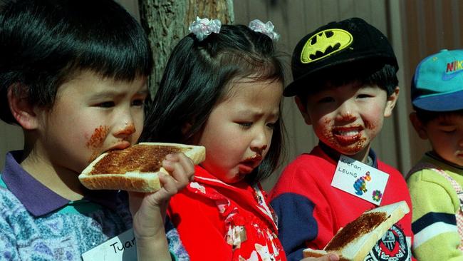 Asian migrant children tuck into vegemite sandwiches.