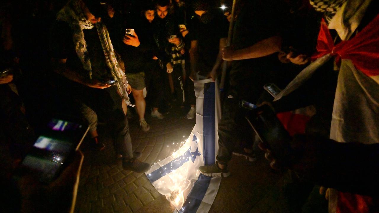 Protesters set fire to an Israeli flag at the Opera House. Picture: NCA NewsWire / Jeremy Piper