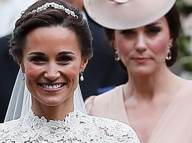 Britain's Catherine, Duchess of Cambridge, (R) follows her sister Pippa Middleton following the wedding of Middleton to James Matthews at St Mark's Church in Englefield, west of London, on May 20, 2017. After turning heads at her sister Kate's wedding to Prince William, Pippa Middleton graduated from bridesmaid to bride on Saturday at a star-studded wedding in an English country church. Middleton married financier James Matthews, 41, at a ceremony attended by the royal couple and tennis star Roger Federer, as she wore a couture dress by British designer Giles Deacon.  / AFP PHOTO / POOL / Kirsty Wigglesworth