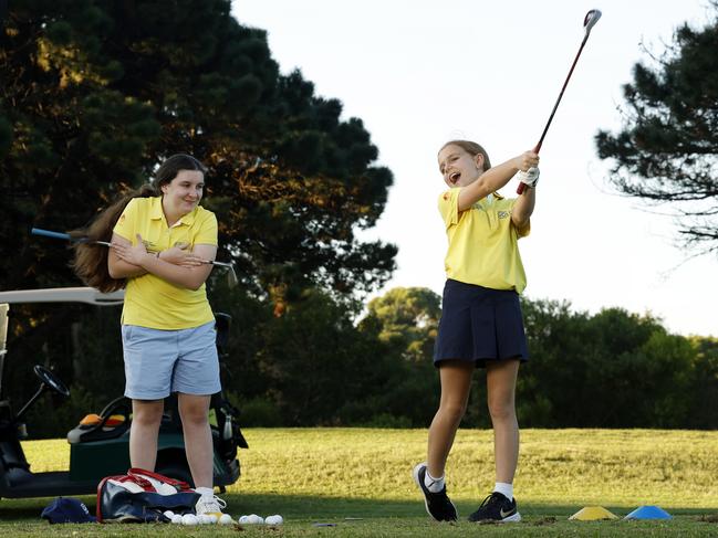 Young golfers Elizabeth Savell, 14, (left) and Eliza Rolfe, 9, during a lesson at East Lakes Golf Club in Pagewood. Picture: Jonathan Ng