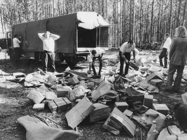 1974: Police and postal investigators search through bags of mail and parcels scattered by bandits in their raid on a mail contractor's truck in the Beerburrum State Forest, Queensland. File picture