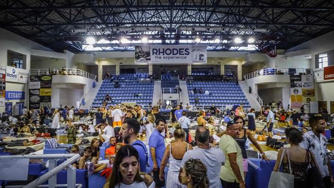 Tourists were forced to spend the night at a basketball hall in Rhodes. (Photo by STRINGER / Eurokinissi / AFP)