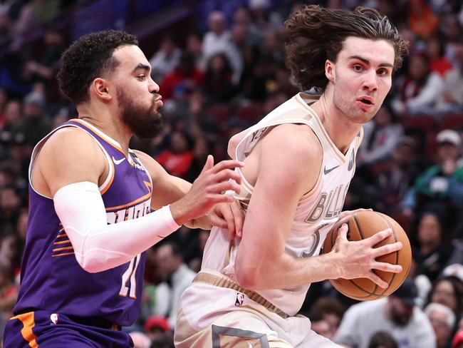 CHICAGO, ILLINOIS - FEBRUARY 22: Josh Giddey #3 of the Chicago Bulls dribbles past Tyus Jones #21 of the Phoenix Suns during the second quarter at the United Center on February 22, 2025 in Chicago, Illinois. NOTE TO USER: User expressly acknowledges and agrees that, by downloading and or using this photograph, User is consenting to the terms and conditions of the Getty Images License Agreement. (Photo by Geoff Stellfox/Getty Images)