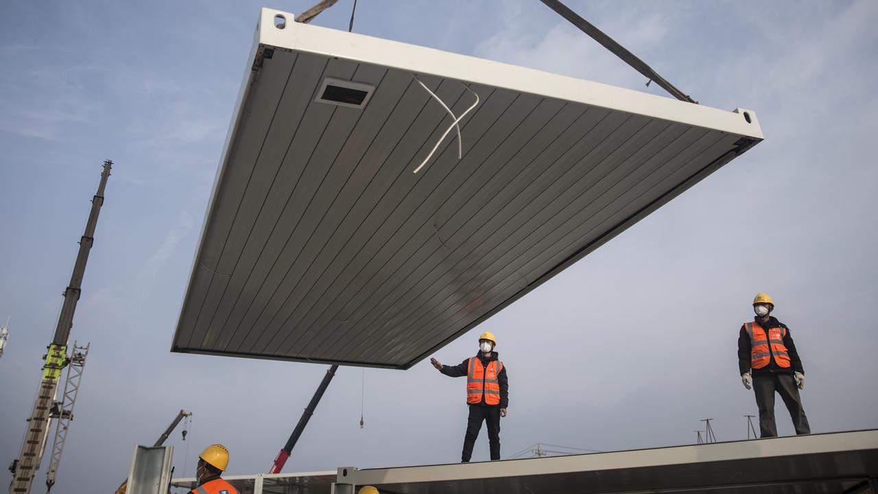 Construction workers guide a crane at the site of Huoshenshan hospital. Picture: Getty Images