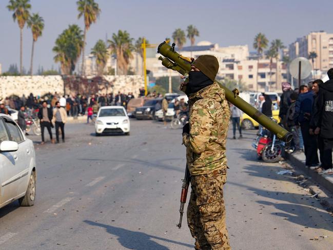 A Syrian anti government fighter carries a shoulder-held surface-to-air missile launcher in the captured central-west city of Hama. Picture: AFP