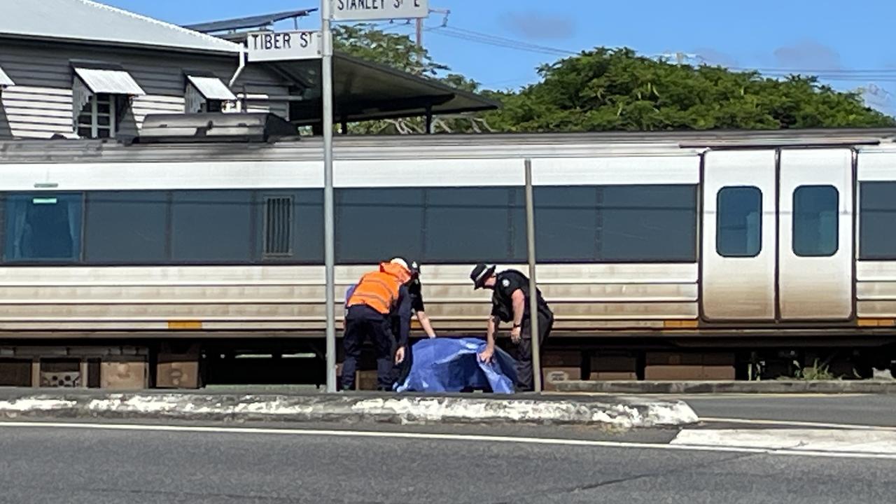 Emergency services and rail workers cover a wheelchair at the scene.