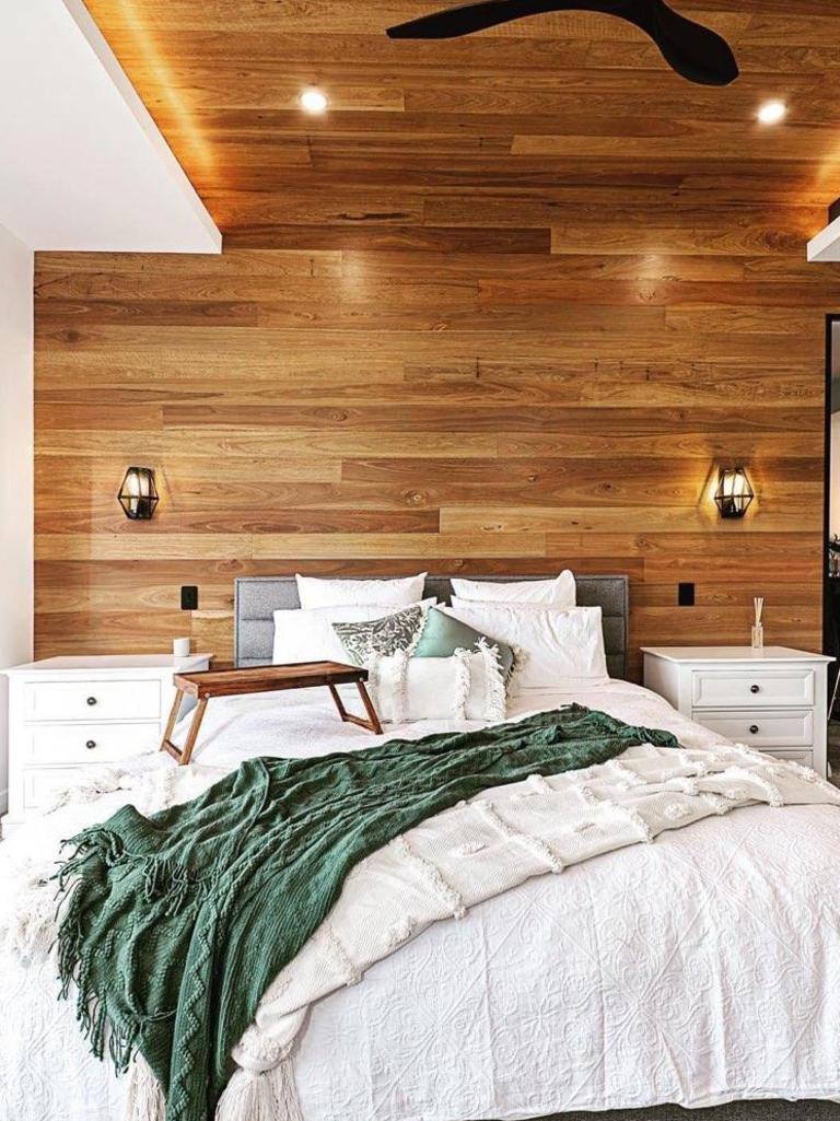 The master bedroom with a timber feature wall that extends up to the ceiling at the Hughes Elite Builders award-winning display home. Photo: Hughes Elite Builders