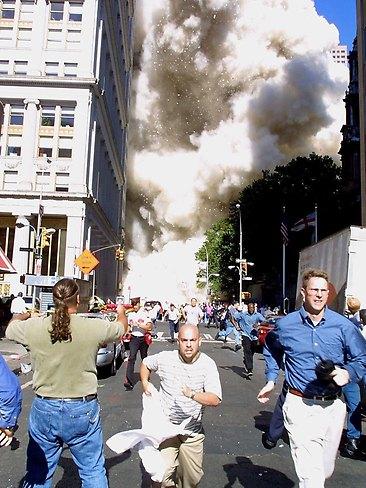 Pedestrians run from the scene as one of the World Trade Centre Towers collapses in New York on September 11, 2001. AFP
