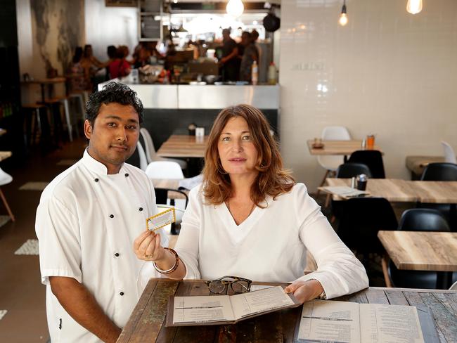 Janelle Williams hands a mammalian meat allergy card to Ground Zero chef Bijay Shrestha. Picture: Troy Snook