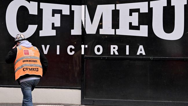 A union official walks past the Victorian headquarters of the Construction, Forestry and Maritime Employees Union (CFMEU) in Melbourne on July 17, 2024. Australia on July 17 pledged to clean up one of its most powerful trade unions, which has been tarred by accusations of intimidating "thuggery", corruption and cosy ties to organised crime. (Photo by William WEST / AFP)