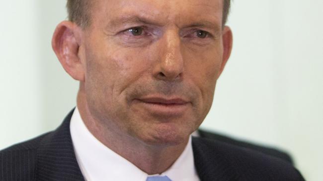 Australian Prime Minister Tony Abbott leaves a meeting of the ruling Liberal Party Monday, Feb. 9, 2015. Beleaguered Prime Minister Abbott survived an internal government challenge to his leadership on Monday, despite a revolt by dozens of colleagues that leaves him politically damaged. (AP Photo/Andrew Taylor)