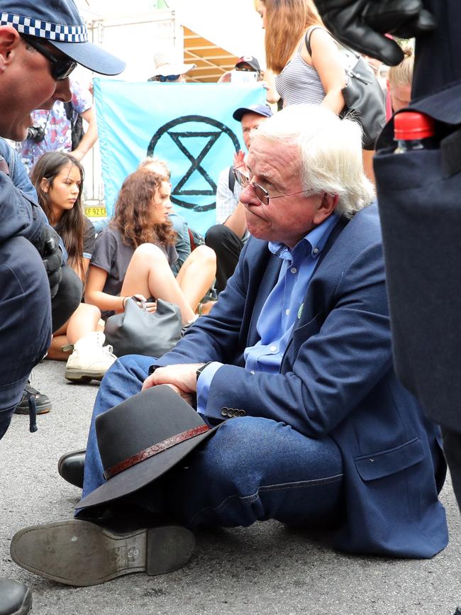 Police speak to a protester before arresting him. Picture: Richard Dobson