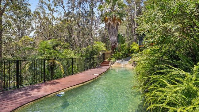 Green Point swimming pool with slide surrounded by nature.