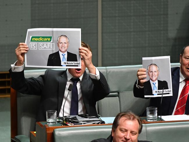 Remember this guy? Labor members Julian Hill and Graham Perrett hold up photos of former prime minister Malcolm Turnbull during Question Time. Picture: AAP