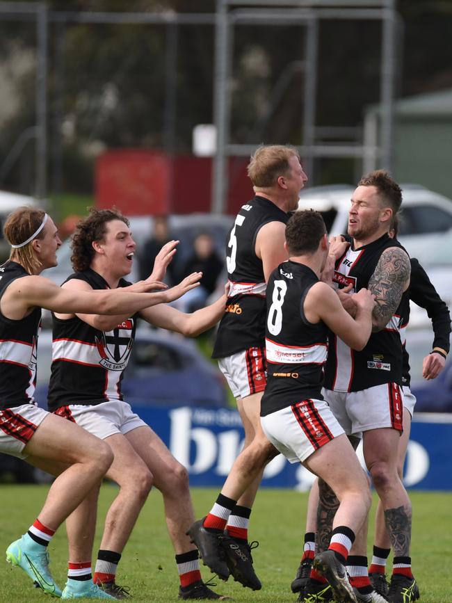 Robinson is swarmed by teammates after kicking his 100th goal. Picture: Thomas Miles