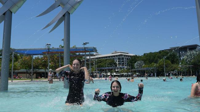 Grace, Patterson, 12, and her sister Summer, 13 escaping the heat under the sprinklers. at the Cairns Lagoon pool on Sunday Picture: Nuno Avendano