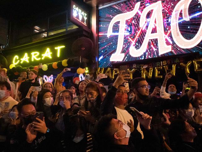 People take photos at Hong Kong’s Lan Kwai Fong area while waiting for countdown during New Year's Eve on December 31, 2021. (Photo by Bertha WANG / AFP)