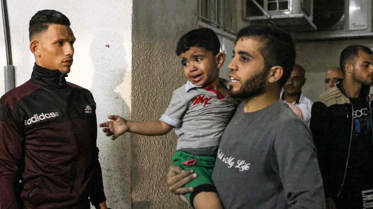 A man brings in a Palestinian child injured in the aftermath of an Israeli air strike to a hospital in Rafah in the southern Gaza Strip on May 13, 2021. Picture: Said Khatib/AFP