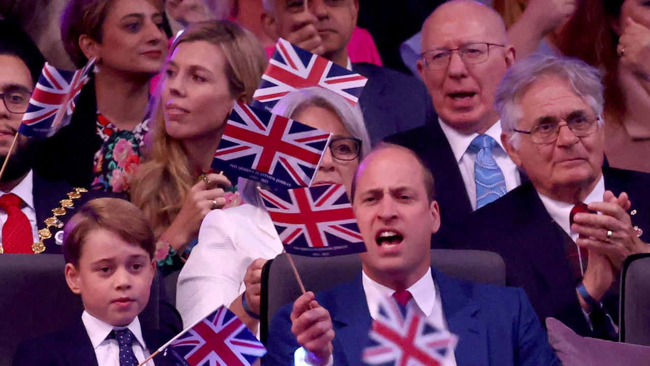 Prince George and Prince William wave Union flags. Picture: Henry Nicholls/AFP