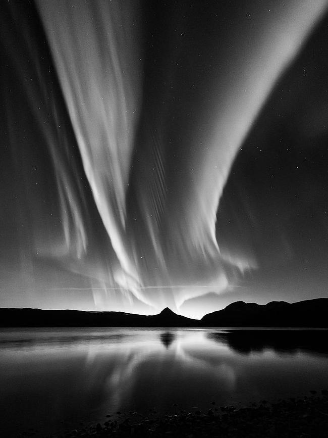 Black and White Aurora ... An unusual view of the aurora, simply in black and white, that turns the expectations of aurora photography on its head. The removal of the vivid colours so commonly associated with the Northern Lights emphasises the fluidity of the aurora and the stark contrast it forms against the night sky. Picture: Kolbein Svensson, Insight Astronomy Photographer of the Year 2016 Aurorae Runner-up