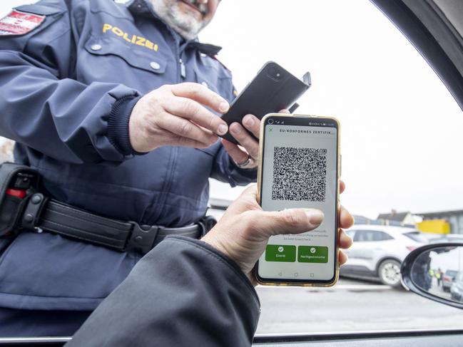 An Austrian police officer checks a driver's digital vaccination certificate on a smartphone during a traffic control in Graz, Austria. Picture: AFP